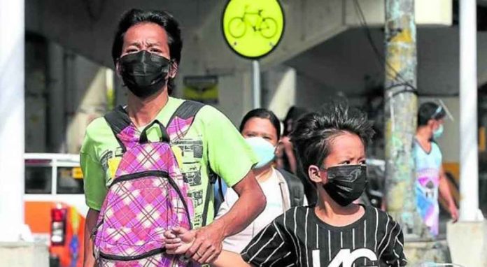 nation2 Citizens pass by the sidewalk of EDSA-Kamias with facemasks on. INQUIRER PHOTO / NINO JESUS ORBETA