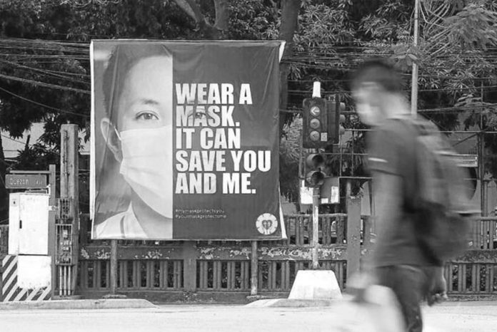 A tarpaulin reminding the public to wear facemasks is installed at the busy corner of Quezon Avenue and Agham Road in Quezon City. With COVID-19 cases in Metro Manila remains high, the Department of Health says people should not be complacent and continue observing minimum health and safety protocols. INQUIRER FILE PHOTO / NIÑO JESUS ORBETA