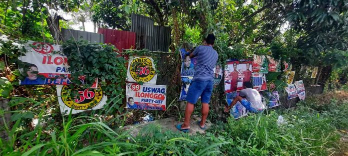 Campaign posters are being removed from a fence in Pavia, Iloilo. The provincial government has ordered an Iloilo-wide post-election cleanup. PHOTO BY MITZI PEÑAFLORIDA