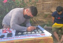 Cops bust ex-convict; P.5-M ‘shabu’ seized Drug suspect Raymond Tatel (right) of Barangay Tigum, Pavia, Iloilo appears to be sulking as a police operative conducts an inventory of the items seized in a buy-bust operation that led to the suspect’s arrest. PN PHOTO