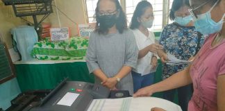 VOTE TESTING. A voter tests feeding a ballot into this vote-counting machine (VCM) during the final testing and sealing of the machines in Iloilo City on Saturday, May 7, in preparation for the elections today, May 9, 2022. A total of 8,570 VCMs will be used in 8,570 clustered precincts across Region 6 today, according to the Commission on Elections. PN PHOTO