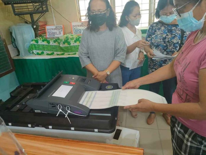 page2-pic VOTE TESTING. A voter tests feeding a ballot into this vote-counting machine (VCM) during the final testing and sealing of the machines in Iloilo City on Saturday, May 7, in preparation for the elections today, May 9, 2022. A total of 8,570 VCMs will be used in 8,570 clustered precincts across Region 6 today, according to the Commission on Elections. PN PHOTO