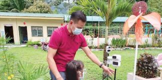 At Laserna Integrated School in Nabas, Aklan, a pupil undergoes a body temperature check. The school has resumed in-person classes.