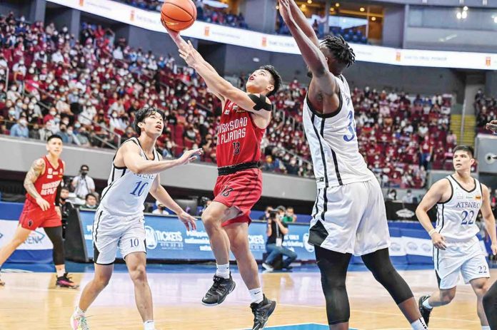 sports-JD University of the Philippines Fighting Maroons’ Joel Cagulangan attempts a basket against the outstretch arms of Ateneo de Manila University Blue Eagles’ Angelo Kouame. UAAP MEDIA BUREAU