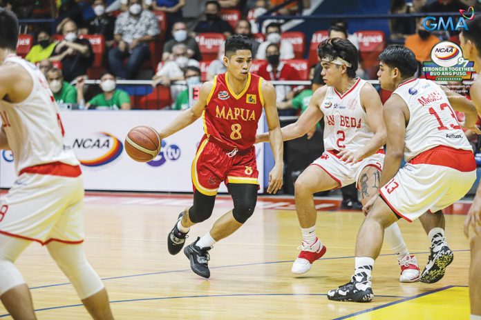 sports-mapua Mapua University Cardinals’ Brian Lacap dribbles the ball while being defended by three San Beda University Red Lions players. PHOTO COURTESY OF NCAA
