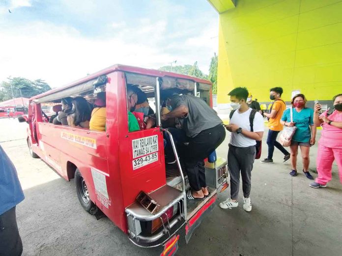 front-glenda-fare-hike Passengers queue to board an Iloilo City-bound jeepney at the Ceres bus terminal in Barangay Buhang, Jaro district. The minimum jeepney fare could rise by P6 if the petition of drivers and operators for such is approved. ARNEL JOHN PALCULLO/PN