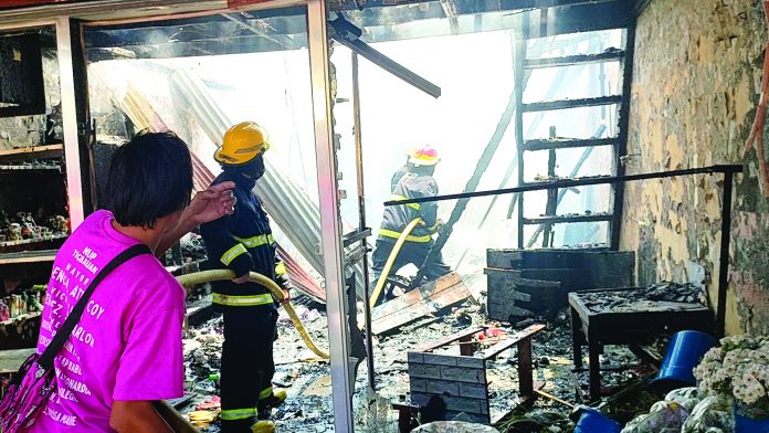 front ime tigbauan This is what’s left of a stall – one of 20 – that fire razed in Tigbauan, Iloilo. Firefighters conduct a mop-up operation. ARNEL JOHN PALCULLO/PN