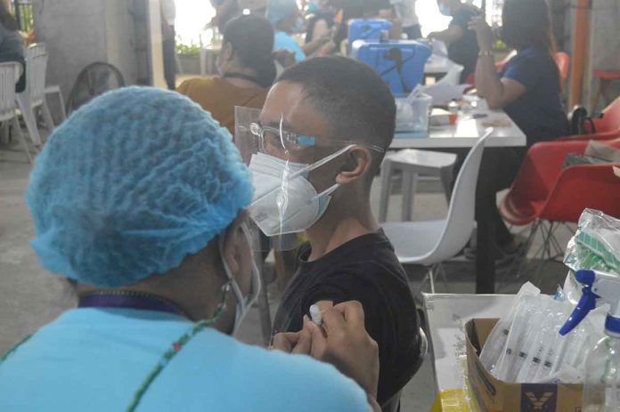 news-glenda-vax-schools A teenager gets his shot of the vaccine against coronavirus disease at a vaccination center in Iloilo City. For children between 12 to 17 years old in the metro, the vaccination is high at 94.88 percent of the 51,580 target population. PN PHOTO