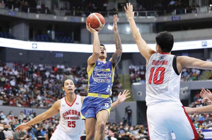 sports-Ginebra Magnolia Chicken Timplados Hotshots’ Jiovani Jalalon attempts a floater against the defense of Barangay Ginebra San Miguel Kings’ Arvin Tolentino. PBA MEDIA BUREAU