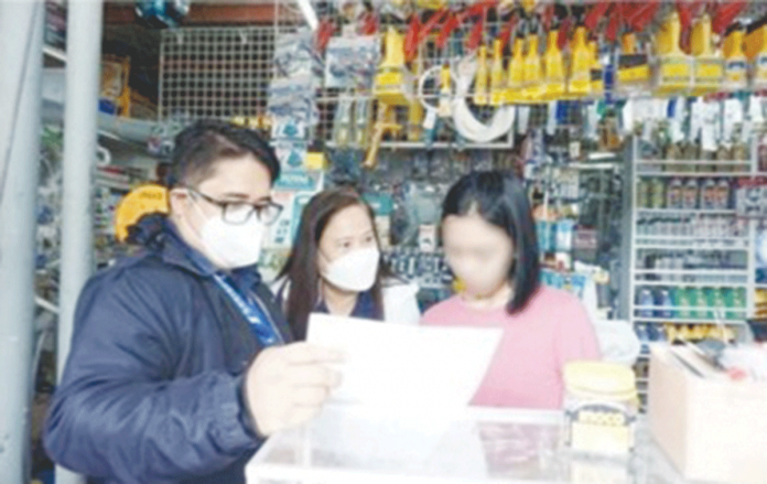 biz-SSS Lilani Benedian (center), SSS Visayas West 1 Division vice president, and lawyer Eduard Dorsey Caratao (left) of SSS Operations Legal Department, during the issuance of a notice to a delinquent establishment on Aug. 4, 2022 in Bacolod City. SSS PHOTO