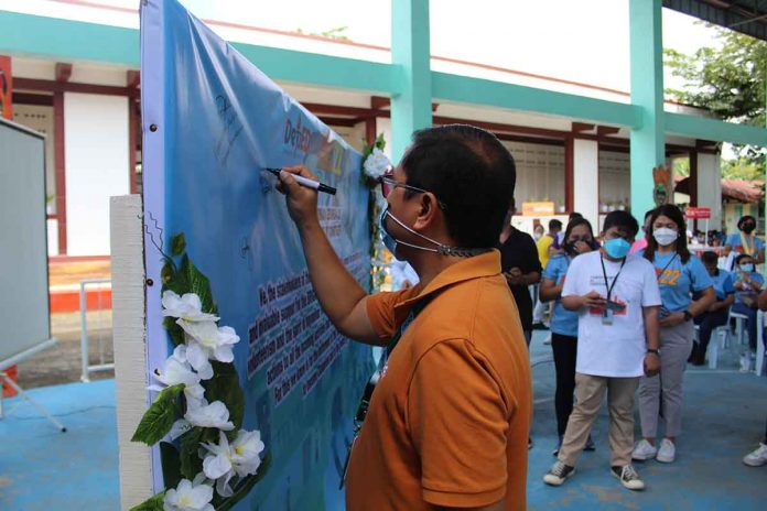 Michael S. Guanco, MGEN – GBP Community Relations Officer, signs the Pledge of Commitment in support of Brigada Eskwela 2022.