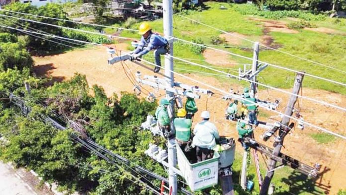 front-pic Personnel of MORE Electric and Power Corporation conduct maintenance work on their power lines in La Paz, Iloilo City. The city’s sole power distributor is set to expand its operation to Iloilo province’s 2nd and 4th districts.