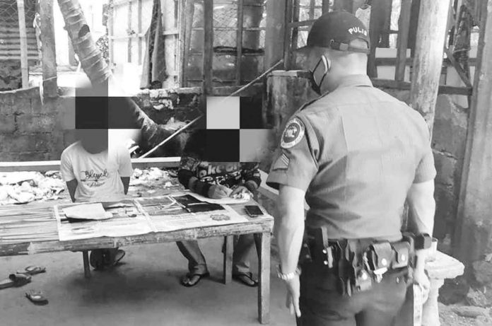 ime-jordan Policemen of Guimaras check the items recovered from a drug suspect in a buy-bust operation. The arrested suspect is seated on the left. JORDAN POLICE STATION PHOTO