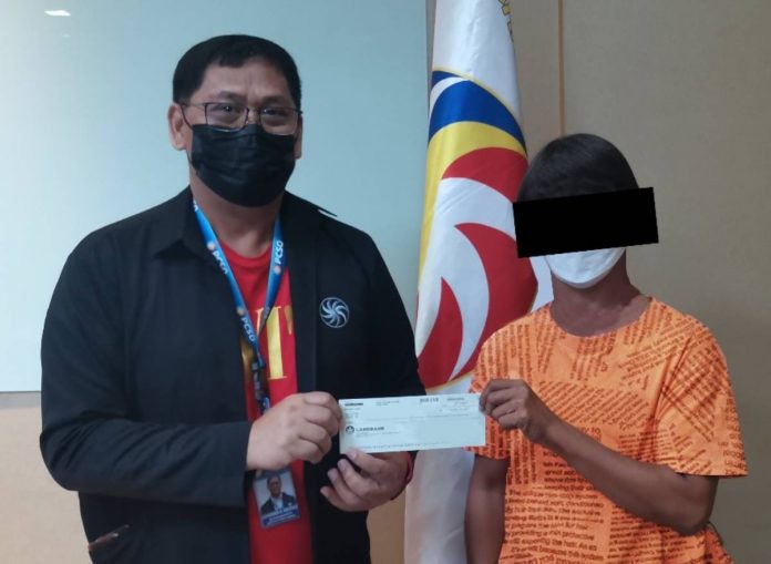 pcso2 (1) In Photo: Representing the Office of the PCSO General Manager, Chief of Staff Dr. Alexander R. Castillo (left) hands over the check to the new Lotto 6/42 jackpot winner. Photo by Eric Delos Reyes