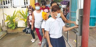 Students and parents/guardians sanitized their hands upon entering the school gate during the opening of classes on August 22, 2022. AJ PALCULLO