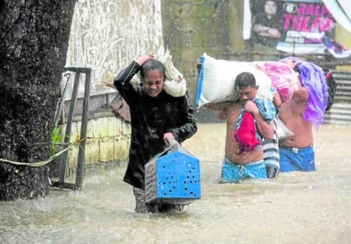 nation1 MUST SAVE EVERYONE. Residents evacuate with their livestock and a few belongings in Barangay Bagong Silangan, Quezon City, one of the low-lying areas where floodwaters rose quickly on Saturday morning as “Paeng” drew nearer to Metro Manila. PHOTO BY LYN RILLON / PHILIPPINE DAILY INQUIRER