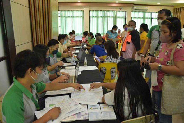 PhilHealth personnel facilitate the registration of members in Nueva Valencia, Guimaras to their chosen KonSulTa provider. Below photo: Personnel of Nueva Valencia RHU conducts health screening and profiling of member registered in the RHU.