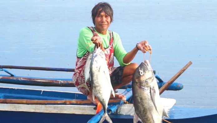 CATCH OF THE DAY. Eddie Panganiban is shown here with Semirara Mining and Power Corporation’s fiberglass banca.