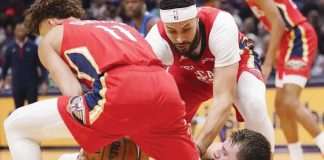 New Orleans Pelicans’ Dyson Daniels (11) and Larry Nance Jr. (in red) gang up on Dallas Mavericks star Luka Doncic (in blue) during a loose ball battle. AP