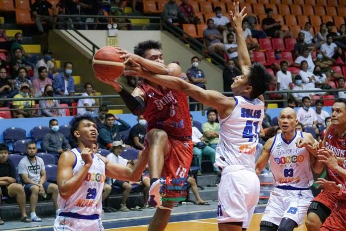 sports-bacolod-pic-and-caption GenSan Warriors’ Nikko Panganiban looks to pass the ball after being hounded by the defense of Bacolod BingoPlus center Jayboy Solis. MPBL PHOTO