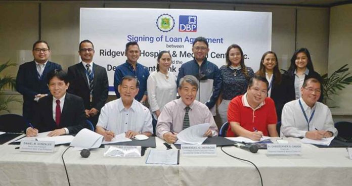 DBP Photo shows Development Bank of the Philippines (DBP) President and Chief Executive Officer Emmanuel Herbosa (seated, third from left) with other key officials of DBP and Ridgeview Hospital and Medical Center, Inc. (RHMCI) during the signing of the memorandum of agreement between the two institutions. Seated from left are DBP Senior Vice President Daniel Gonzales; RHMCI president, Fr. Arturo Joseph Balagat; RHMCI chairman, Dr. Christopher Cabida; and DBP Executive Vice President Paul Lazaro. Standing from left are Russel Lance Ragudo of DBP; DBP Assistant Vice President Brian Niño Juniller; Dr. Jerome Idea, Dr. Jenny Lynn Idea, Dr. Cipriano Delos Reyes, and Caroline Cabida of RHMCI; and Mgr. Ana Patricia Gaviola and Christine Allaine Saporsantos of DBP.