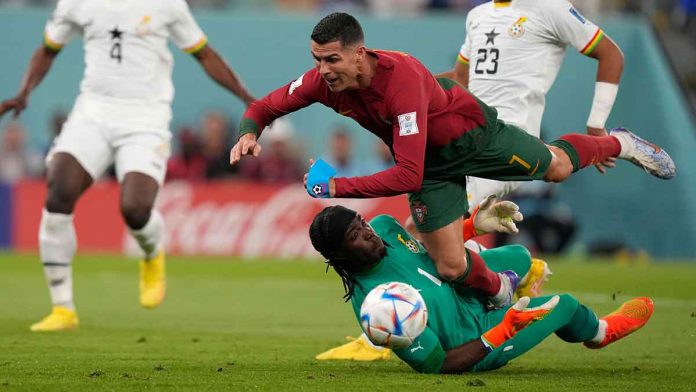 sports-World-Cup Portugal’s Cristiano Ronaldo falls over Ghana goalkeeper Lawrence Ati-Zigi. AP