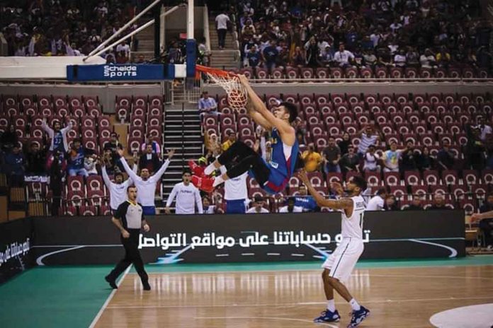 Gilas Pilipinas’ Kai Sotto hangs on the ring for a two-handed dunk during their game against Saudi Arabia in the fifth window of the 2023 FIBA World Cup Asian Qualifiers in Jeddah, Saudi Arabia. FIBA Photo