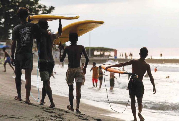 Men carry surf boards as they walk along the beach in San Juan, La Union – a popular tourist spot. BASILIO H. SEPE/ABS-CBN NEWS PHOTO