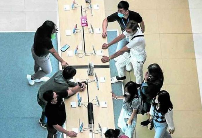 nation-SIM Shoppers check out the latest models of mobile phones at a kiosk in a mall in Mandaluyong City a day after Christmas. PHOTO BY LYN RILLON / PHILIPPINE DAILY INQUIRER