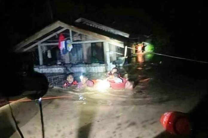 nation-rain This handout photo taken on Dec. 25, 2022 and received on Dec. 26 from the Philippine Coast Guard shows rescuers evacuating people from a flooded area in Ozamiz City, Misamis Occidental. Two people were killed and nearly 46,000 others fled their homes as Christmas Day floods dampened the mainly Catholic Philippines’ most important holiday, civil defence officials said. Photo by Handout / Philippine Coast Guard / AFP