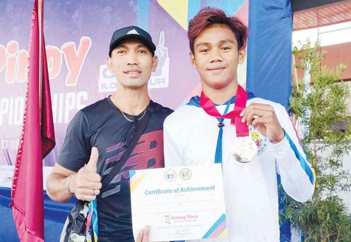 sports-bacolodnon Bacolodnon hurdler Mico Villaran displays his gold medal with his head coach Miguel Arca. PHOTO COURTESY OF MIGUEL ARCA