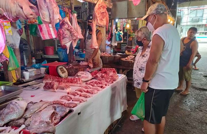 tarriffs Executive Order No. 171 adjusts the tariffs of meat of swine, fresh, chilled, or frozen at 15 percent (in-quota) and 25 percent (out-quota). Photo shows buyers checking pork meat products at the Iloilo Terminal Market. AJ PALCULLO/PN