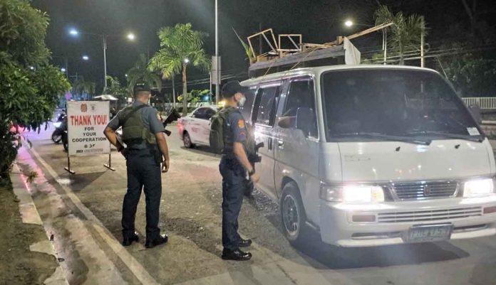 checkpoint Police officers flag down vehicles for inspection at a checkpoint in Barangay Ungka, Jaro, Iloilo City. PN PHOTO