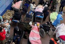 Patients lie on beds and stretchers in a hallway in the emergency department of a Shanghai hospital. REUTERS