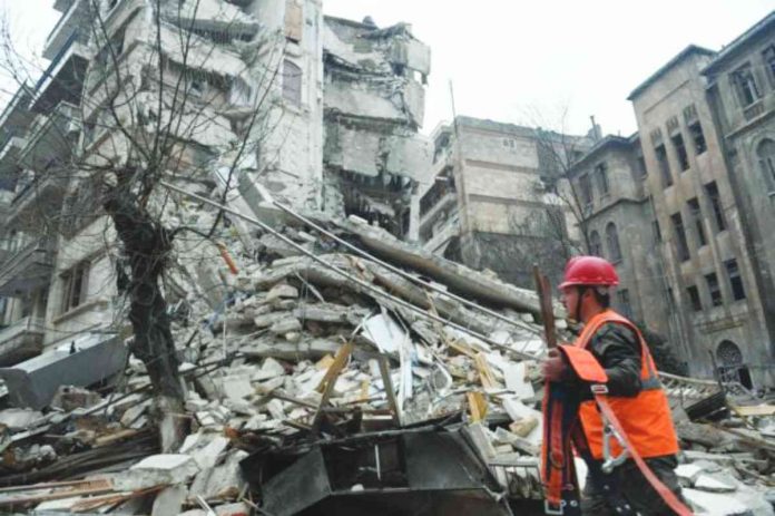 A member of a rescue team walks with his tools towards a collapsed building following an earthquake in the government-held Syrian city of Aleppo on Feb. 6, 2023. A 7.8-magnitude earthquake hit Turkey and Syria on Feb. 6, killing thousands of people as they slept, leveling buildings, and sending tremors that were felt as far away as the island of Cyprus and Egypt. AFP