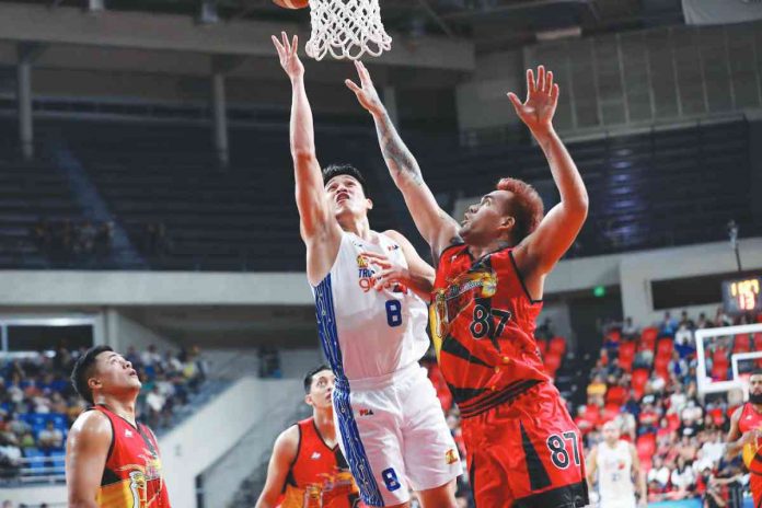 TNT Tropang Giga’s Calvin Oftana scores against the defense of San Miguel Beermen’s Vic Manuel. PBA PHOTO