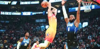 Jayson Tatum of Team Giannis goes for a two-handed dunk as LeBron James of Team LeBron turns his back. AP