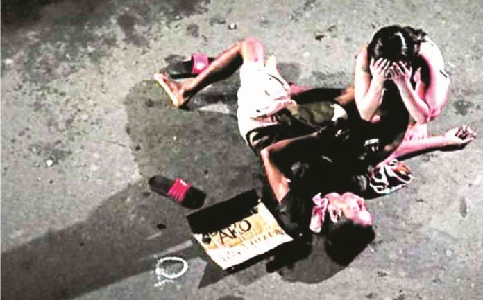 JK VICTIM. Jennelyn Olaires weeps beside her partner, alleged drug pusher Michael Siaron, 30, a pedicab driver who was shot and killed by unidentified suspects in July 2016. INQUIRER FILE PHOTO