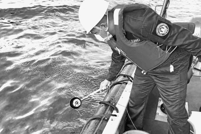 nation spill WATER SAMPLING. In this handout photo from the Philippine Coast Guard taken on March 2, 2023, a coastguard personnel collects water samples from an area hit by oil spill off the waters of Naujan, Oriental Mindoro. The spill, a mix of industrial fuel and oil, came from a tanker that sank there on Feb. 28.