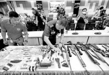 FIREPOWER. Personnel of the Criminal Investigation and Detection Group check the firearms and bullets seized during a raid on the property of former Negros Oriental Gov. Pryde Henry Teves, younger brother of suspended Rep. Arnolfo Teves Jr., before these are presented at a news briefing on Monday, March 27, 2023. PHOTO BY GRIG C.MONTEGRANDE / PHILIPPINE DAILY INQUIRER