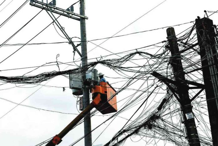 power outages Linemen work on tangled electric cables in Quezon City. GEORGE CALVELO/ABS-CBN NEWS PHOTO