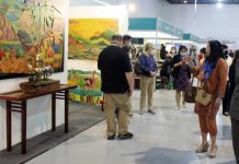Department of Tourism (DOT) undersecretary Shereen Gail Yu-Pamintuan (right) looks at the exhibit painting display during the first leg of the DOT-Department of Labor and Employment job fair at the SMX Convention Center Manila. PNA PHOTO BY GIL CALINGA