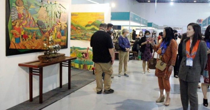 job fair Department of Tourism (DOT) undersecretary Shereen Gail Yu-Pamintuan (right) looks at the exhibit painting display during the first leg of the DOT-Department of Labor and Employment job fair at the SMX Convention Center Manila. PNA PHOTO BY GIL CALINGA