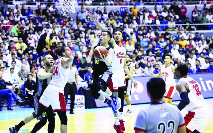 sports TNT Bacolodnon Kib Montalbo of TNT Tropang Giga evades the defense of Barangay Ginebra San Miguel Kings’ Christian Standhardinger and Jeremiah Gray for a tough basket. PBA PHOTO