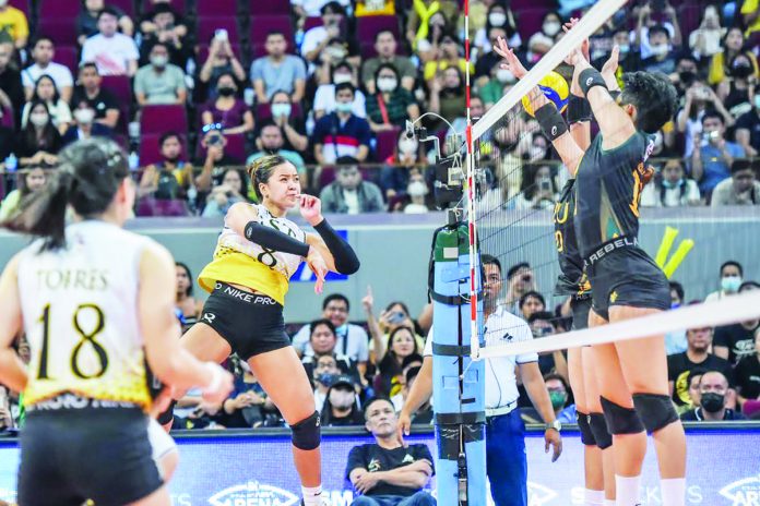 sports_UST_resized University of Santo Tomas Golden Tigresses’ Ejiya Laure slams the ball towards the defense of Far Eastern University Lady Tamaraws. UAAP PHOTO