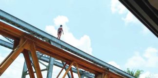 Robbery suspect Fernando Camporaso Jr. climbed onto trusses of the Caliban bridge in Barangay Caliban, Murcia, Negros Occidental on Sunday, May 14, after carting away P7,800 in cash from a lending collector. APRIL MAHUSAY PHOTO