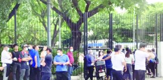 Employees stand outside the Philippine International Convention Center after a bomb threat was sent to the National Privacy Commission’s Facebook page. The social media user was later arrested by the National Bureau of Investigation in Malinao, Aklan. ALI VICOY VIA MANILA BULLETIN PHOTO