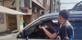 A traffic enforcer hands out a flyer about the paid parking ordinance of Iloilo City. The city government starts collecting parking fees from owners of parked vehicles on Monday, May 15. CITY GOV’T OF ILOILO FB PHOTO