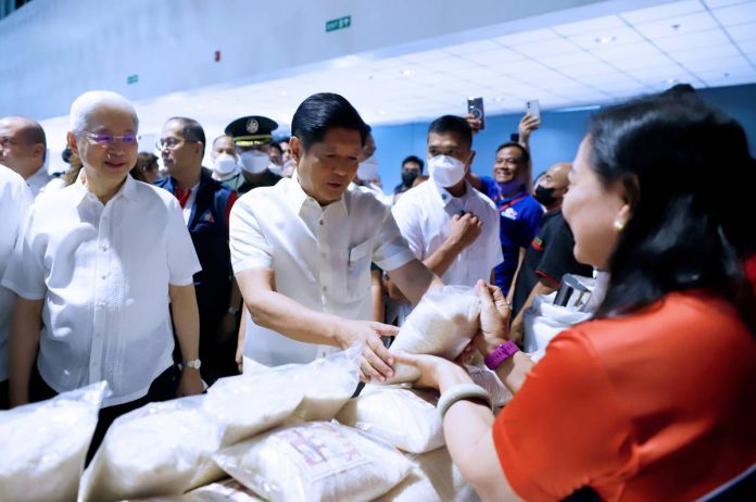 President Ferdinand R. Marcos Jr. inspects packed rice for sale at a “Kadiwa ng Pangulo Para Sa Manggagawa” outlet in Pasay City, with Department of Trade and Industry Secretary Alfredo Pascual (left). The President has vowed to make rice more affordable. PNA