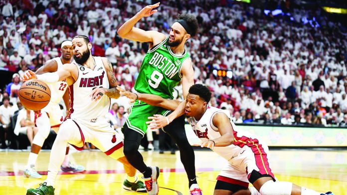 sports_NBA_resized Derrick White of the Boston Celtics is being flanked by Miami Heat players. AP